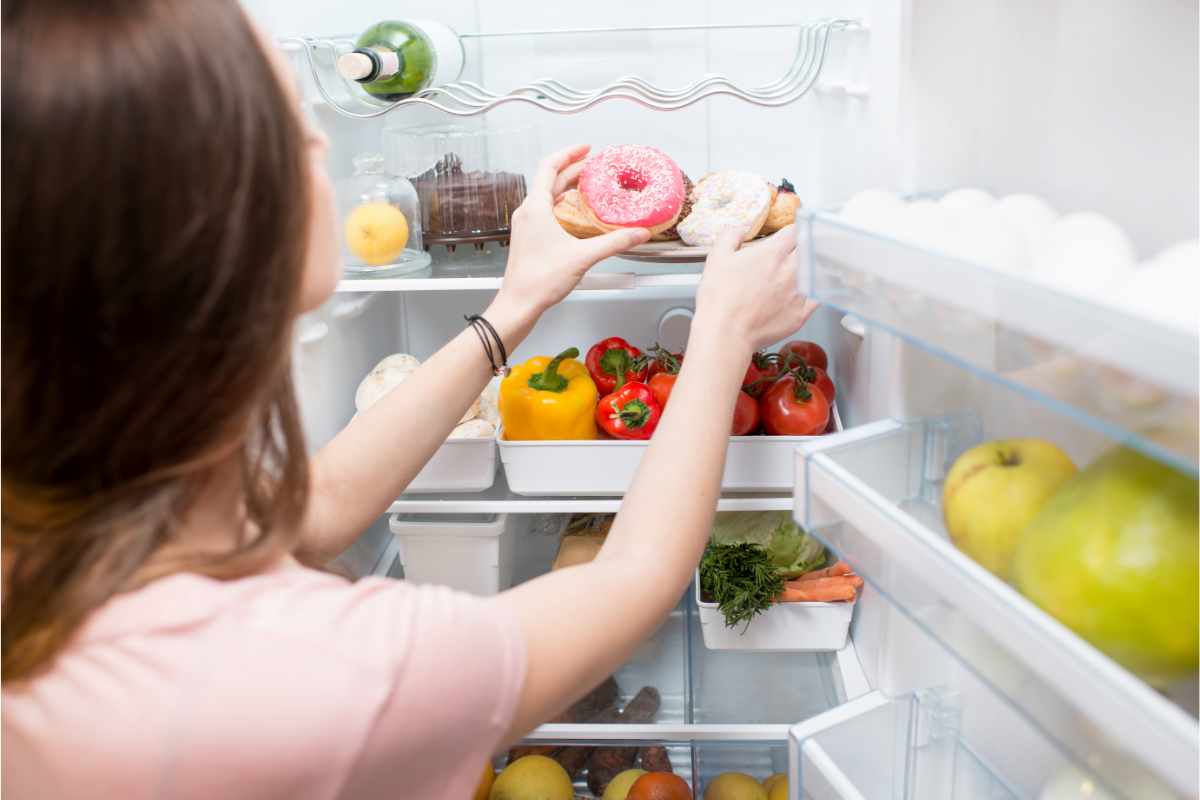 Una donna che sistema del cibo in frigorifero