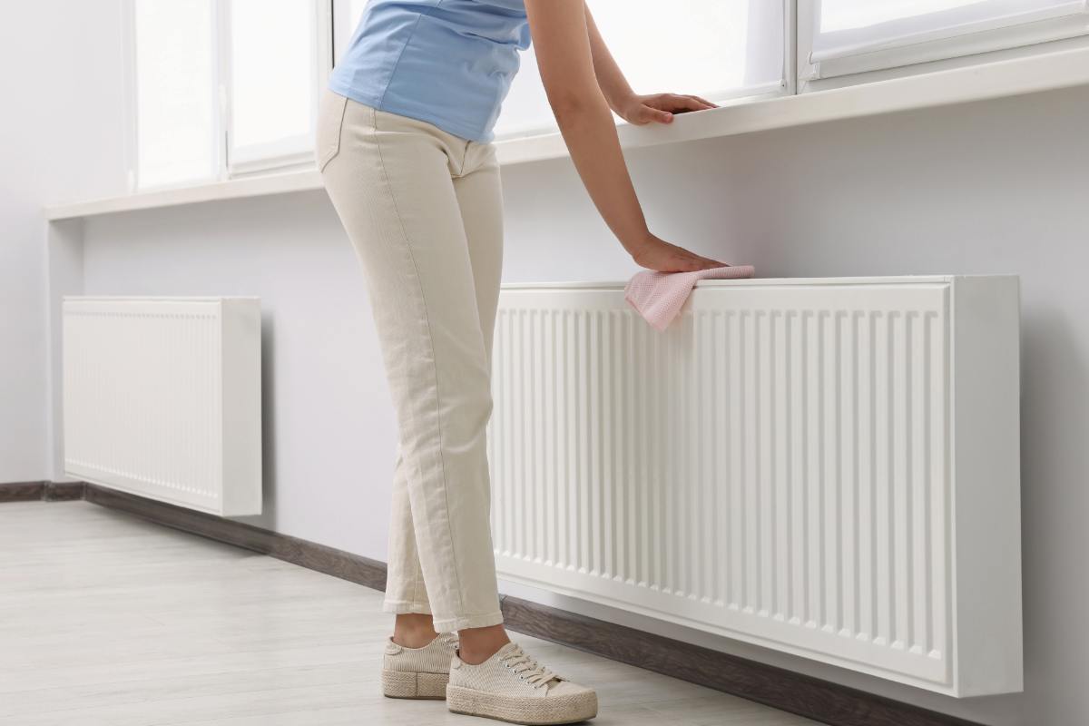 Donna pulisce il termosifone