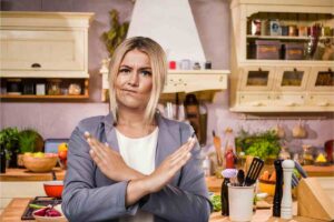 Una donna arrabbiata in una cucina in disordine