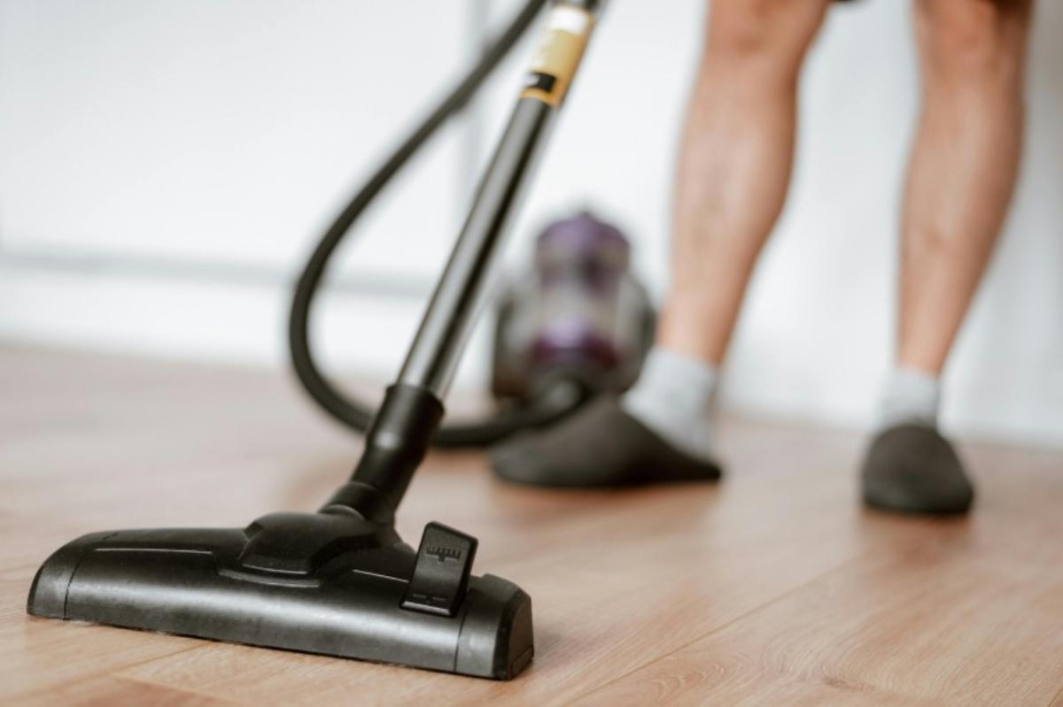 Uomo che pulisce con aspirapolvere