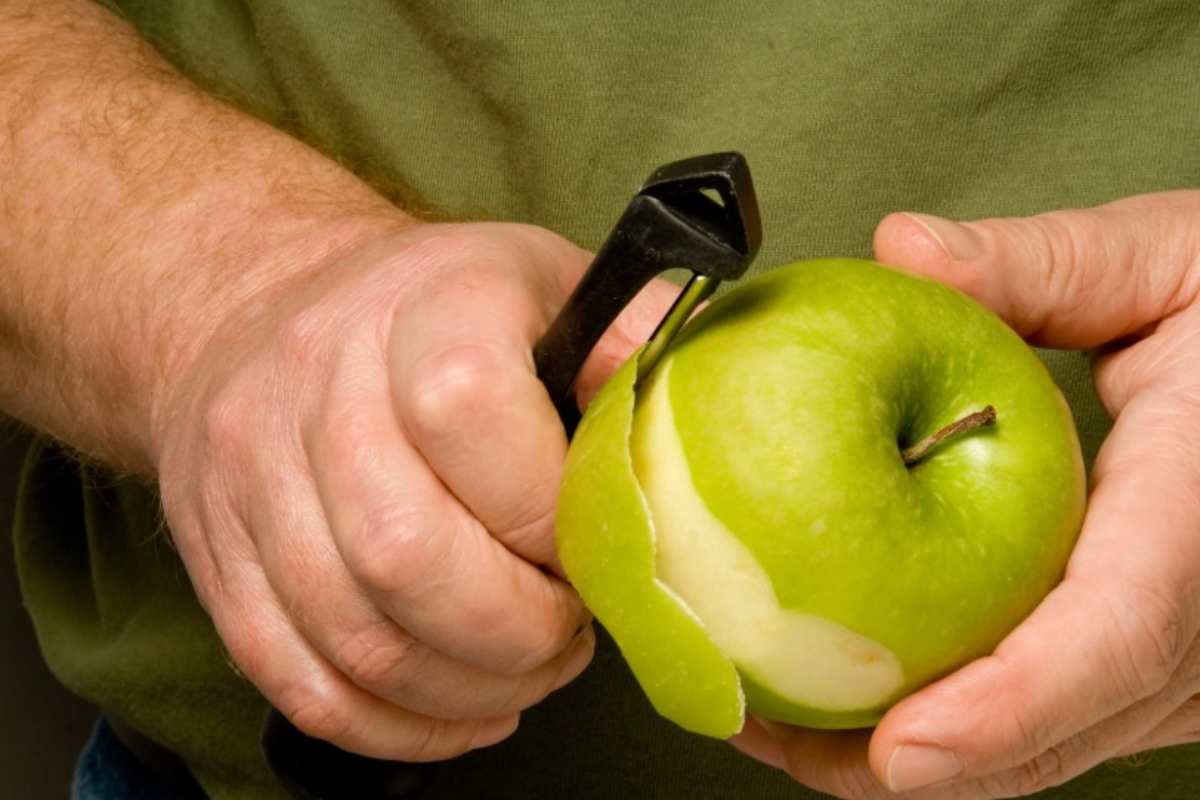 Uomo che sbuccia una mela