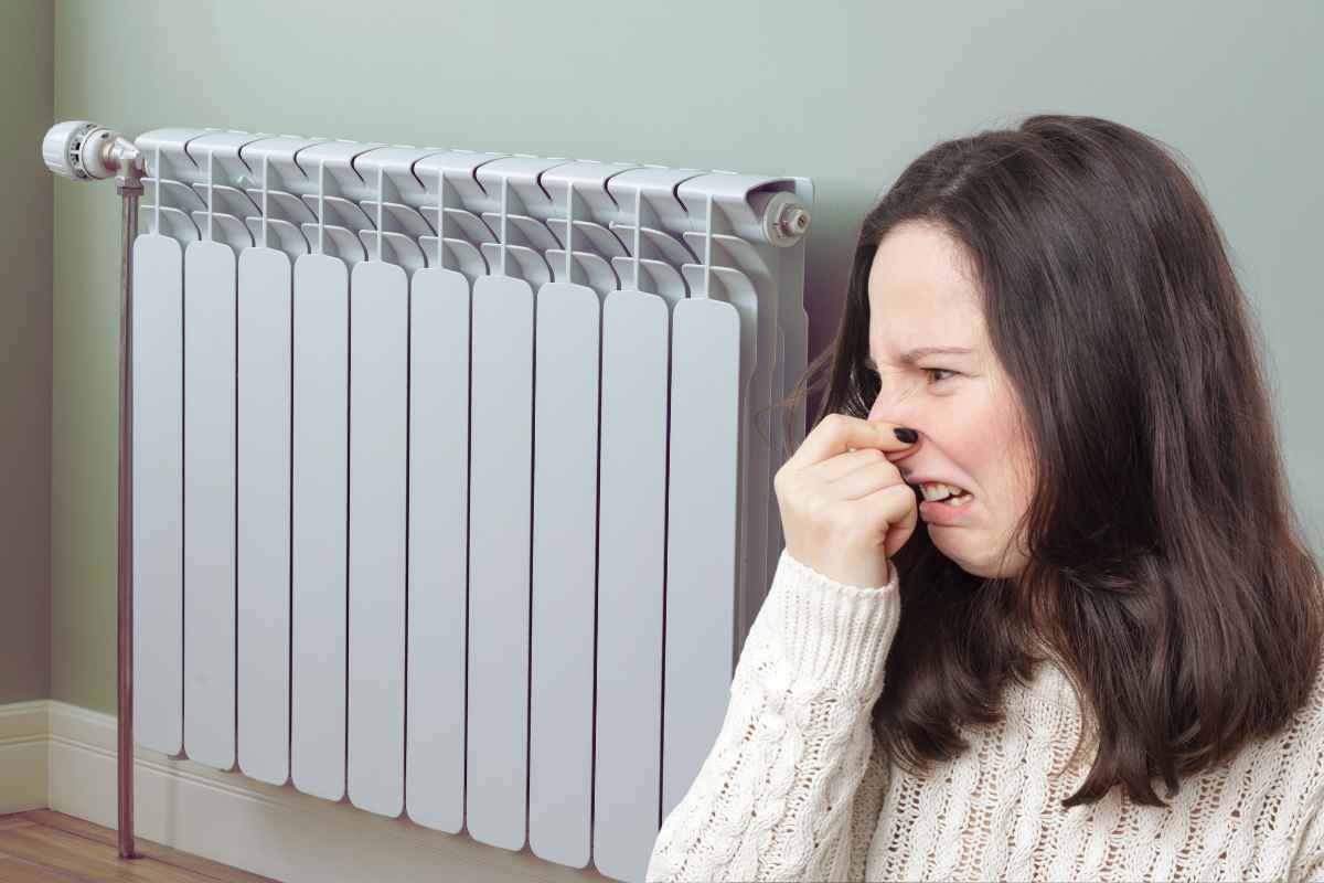 termosifone e donna che si tappa il naso