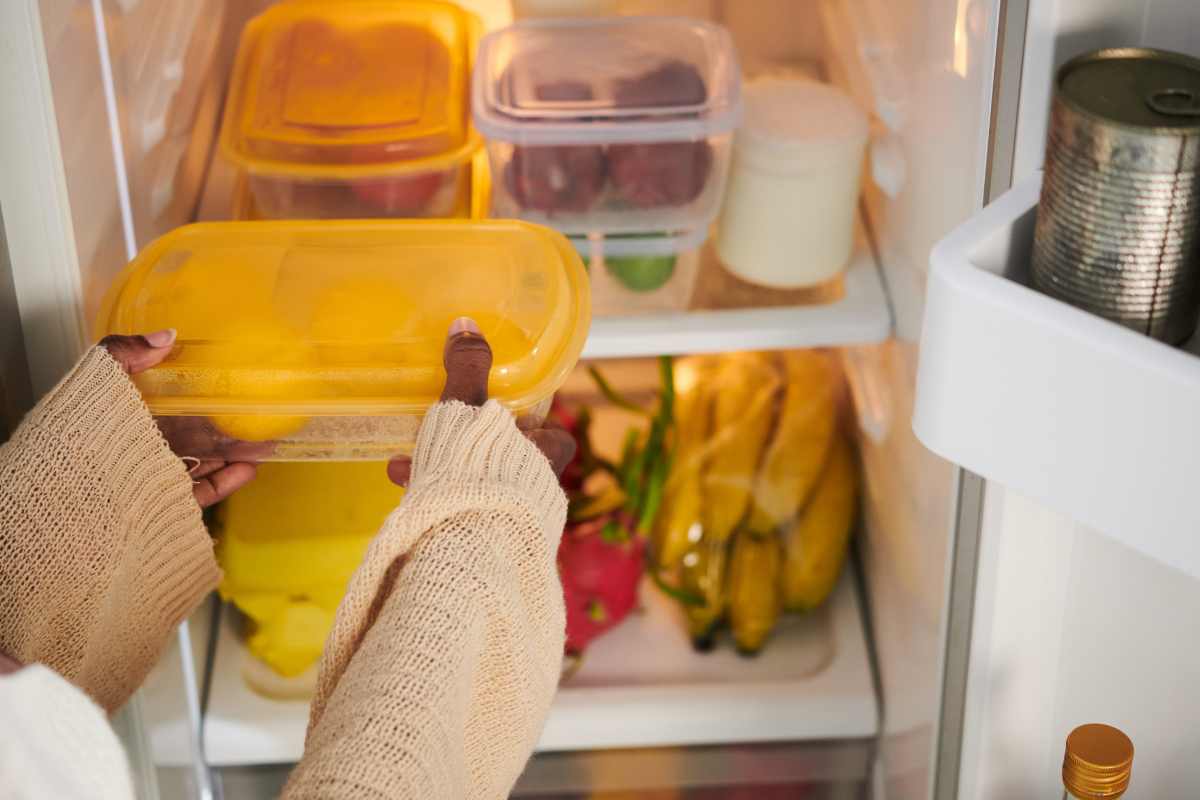 donna posa contenitore in frigorifero