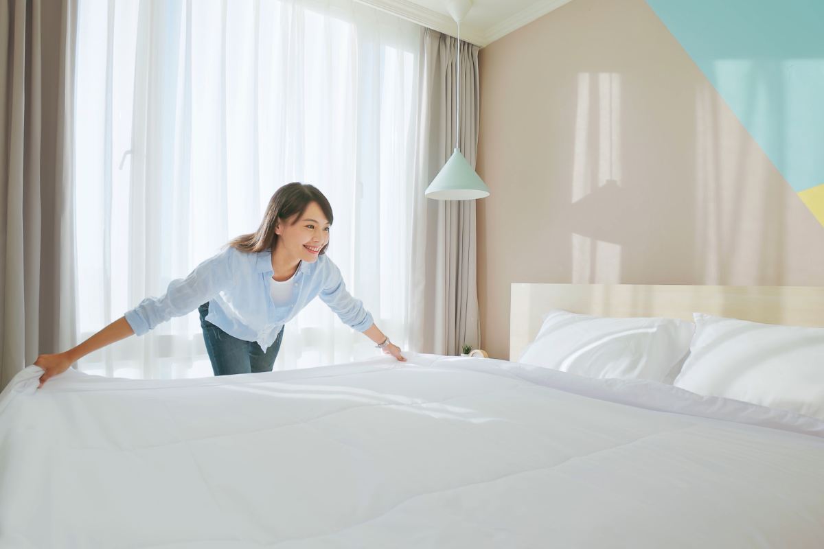 ragazza che sistema il letto